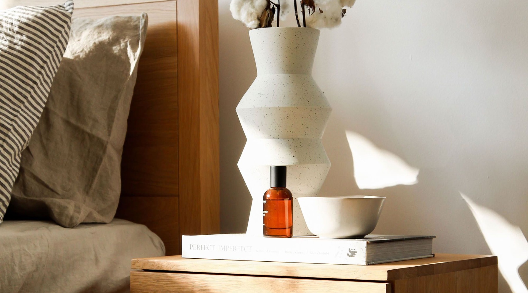 books and decor on a table next to a bed