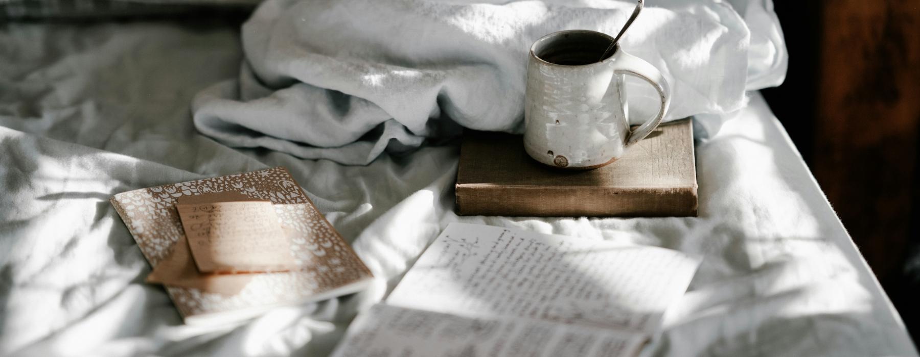a coffee and books on a bed