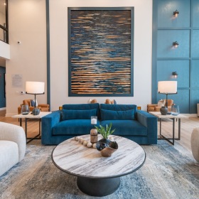 a clubroom with a coffee table, couches and a painting
